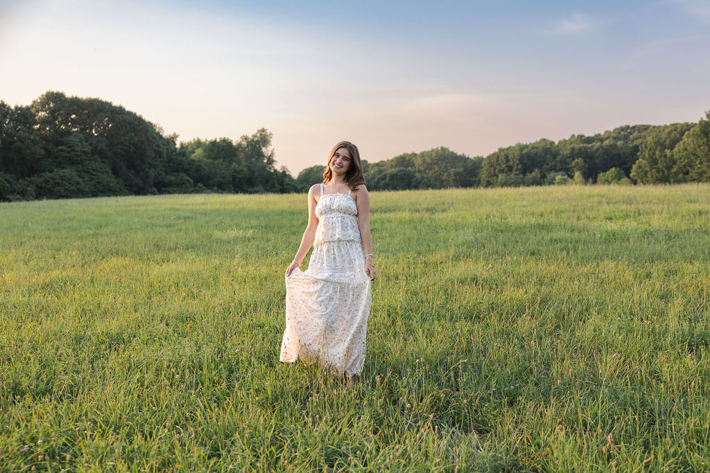 woman-in-white-dress-standing-in-open-green-field