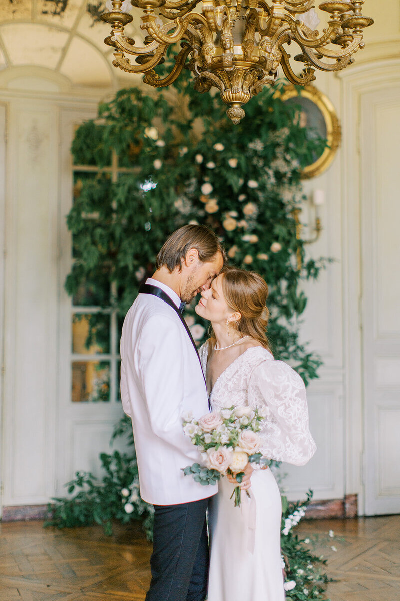 wedding-couple-posing-with-flower-bouquet-indoors